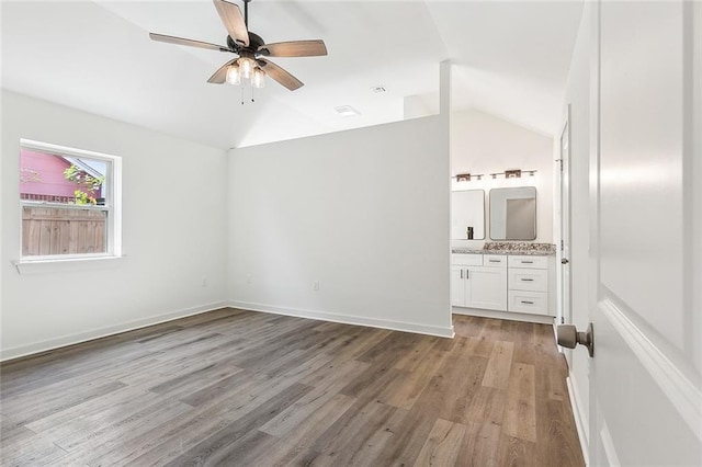 unfurnished bedroom with lofted ceiling, connected bathroom, light hardwood / wood-style floors, and ceiling fan