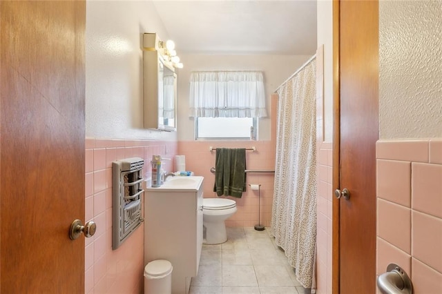 bathroom with vanity, toilet, tile patterned flooring, and tile walls