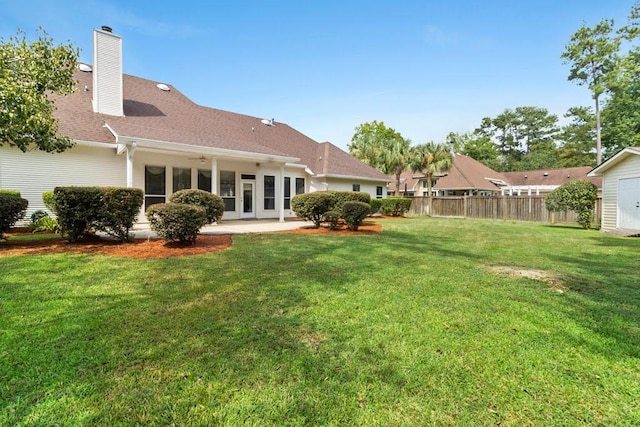 back of property with a yard and a patio