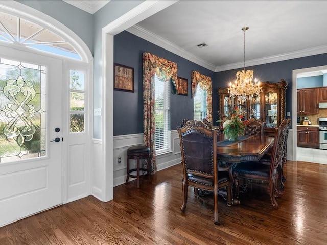 dining area with ornamental molding, dark hardwood / wood-style floors, and a chandelier