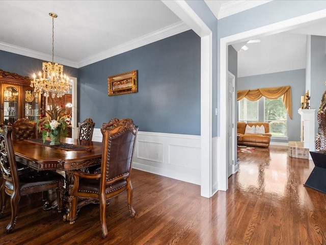 dining space with hardwood / wood-style flooring, ornamental molding, and a chandelier