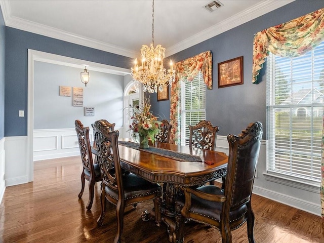 dining area with hardwood / wood-style floors, crown molding, and plenty of natural light