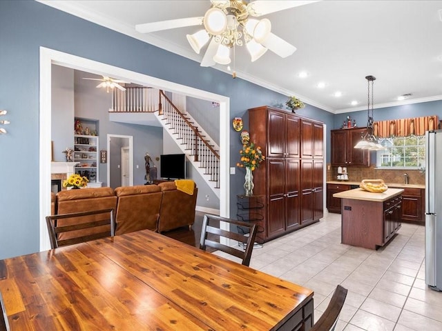 tiled dining room with sink, ornamental molding, and ceiling fan