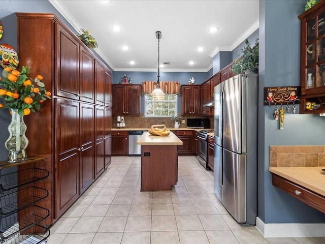 kitchen with appliances with stainless steel finishes, pendant lighting, tasteful backsplash, a center island, and crown molding