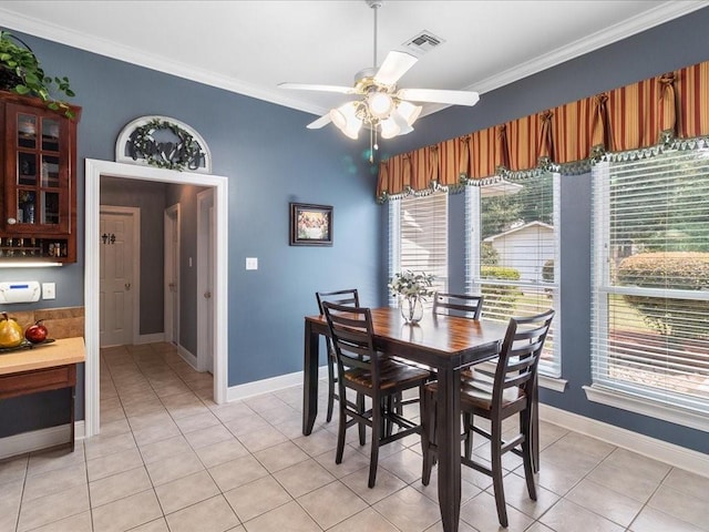 dining space with crown molding, light tile patterned floors, and ceiling fan