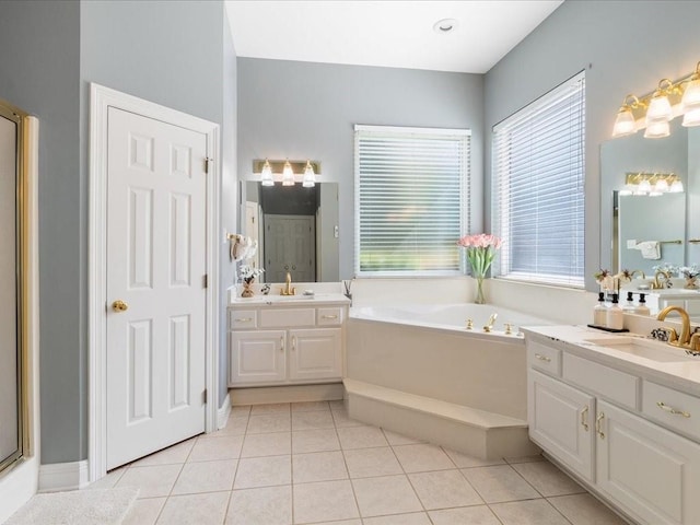 bathroom with a washtub, vanity, and tile patterned floors