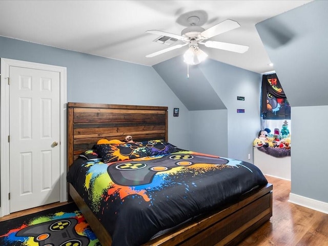 bedroom with hardwood / wood-style flooring, vaulted ceiling, and ceiling fan