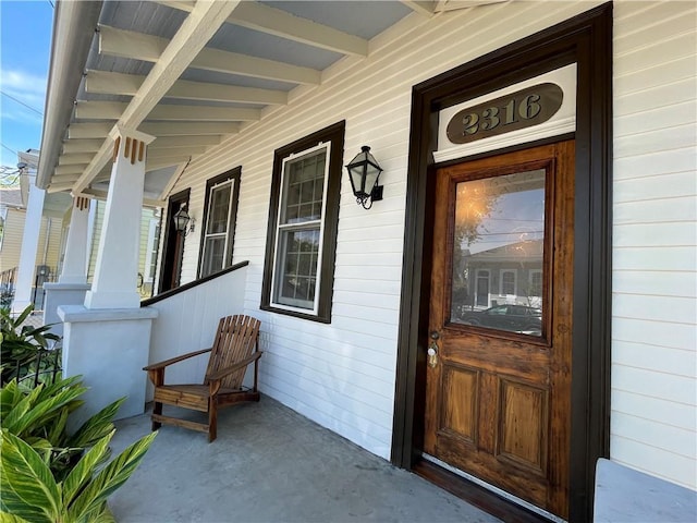 view of exterior entry with a porch