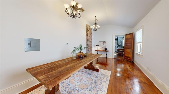 corridor with dark wood-type flooring, lofted ceiling, electric panel, and a notable chandelier