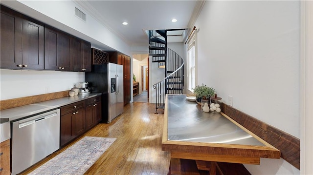 kitchen featuring stainless steel appliances, crown molding, dark brown cabinets, and light hardwood / wood-style flooring