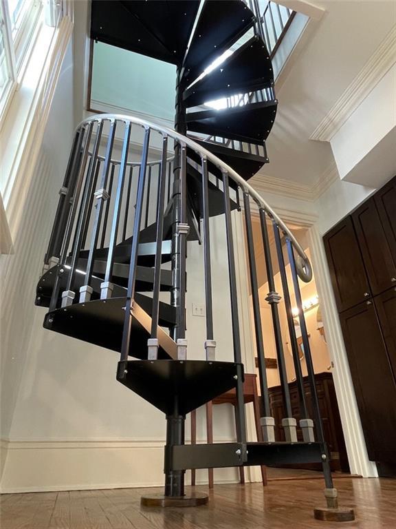 stairway featuring hardwood / wood-style flooring and ornamental molding