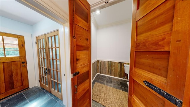 interior space with ornamental molding and wood walls