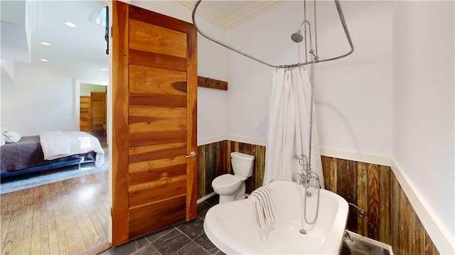 bathroom with ornamental molding, toilet, and shower / bath combo