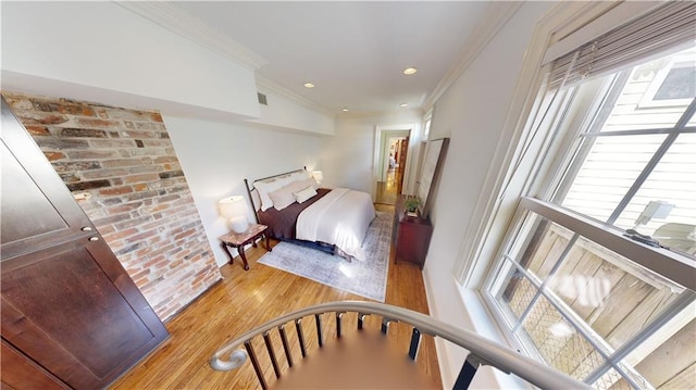 bedroom with crown molding and light hardwood / wood-style floors