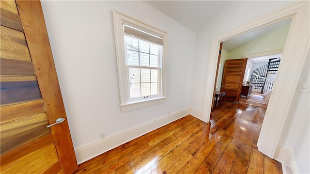 hallway featuring wood-type flooring and lofted ceiling