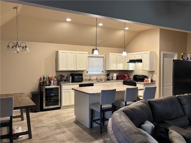 kitchen with black appliances, white cabinetry, beverage cooler, and decorative light fixtures