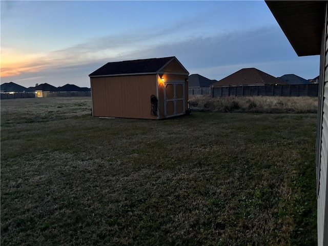 yard at dusk featuring a shed