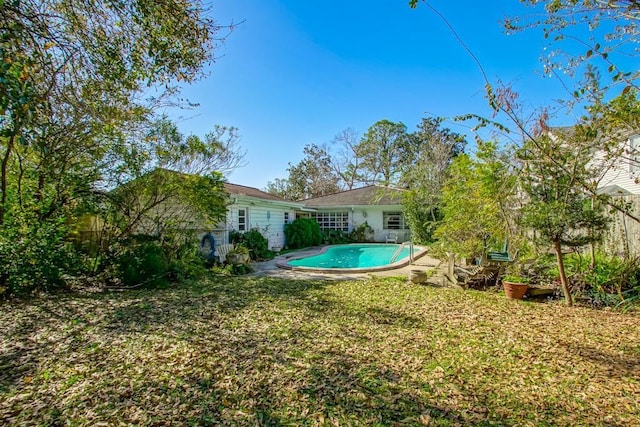 back of house featuring a fenced in pool and a yard