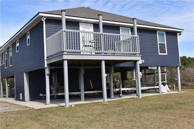 back of property with roof with shingles and a lawn