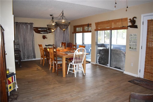 dining room featuring dark wood-style floors, a textured ceiling, and baseboards