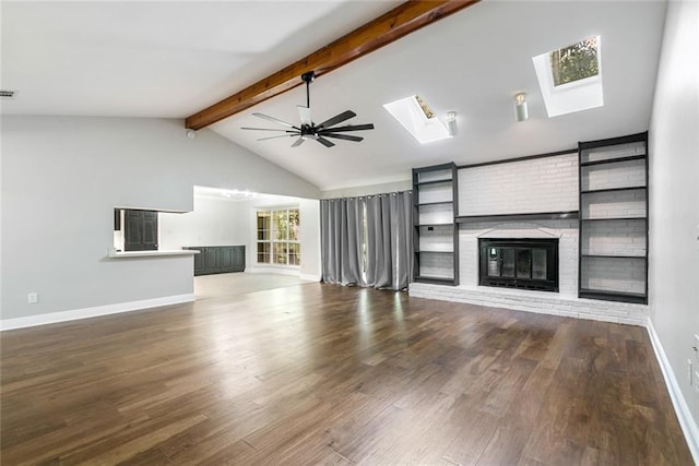 unfurnished living room featuring lofted ceiling with skylight, wood-type flooring, ceiling fan, and a fireplace