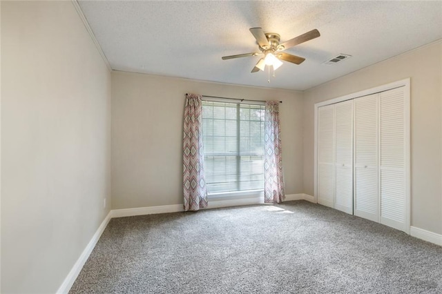 unfurnished bedroom with carpet floors, a textured ceiling, ceiling fan, and a closet