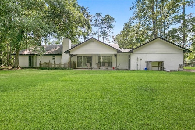 rear view of property featuring a lawn