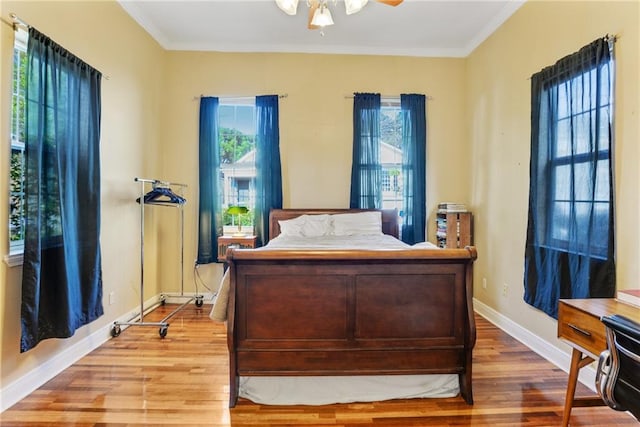 bedroom featuring crown molding, ceiling fan, and wood-type flooring