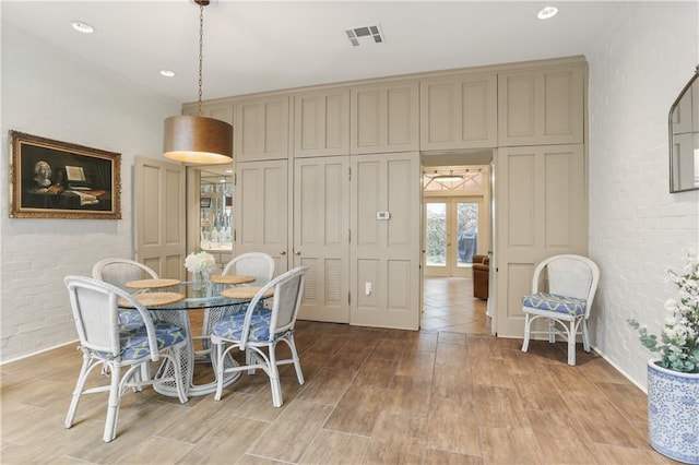 dining area with french doors and brick wall