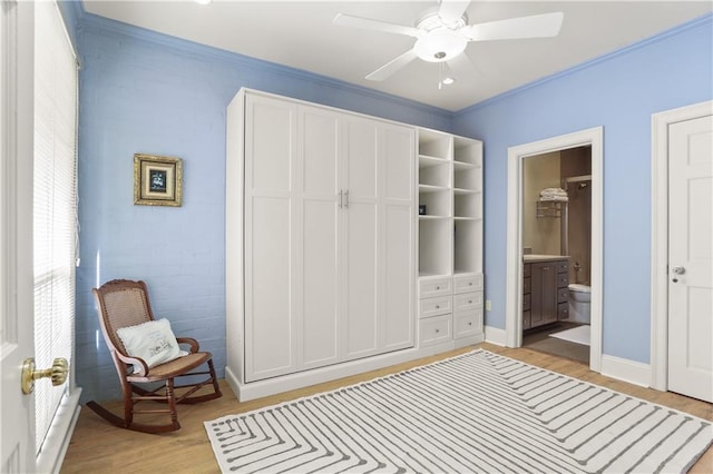 interior space with ceiling fan, ornamental molding, ensuite bath, and light hardwood / wood-style flooring