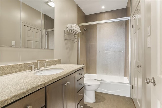 full bathroom with vanity, enclosed tub / shower combo, and toilet