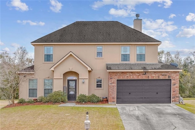 view of property with a garage and a front lawn