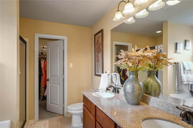 bathroom with vanity, a shower with shower door, tile patterned floors, and toilet