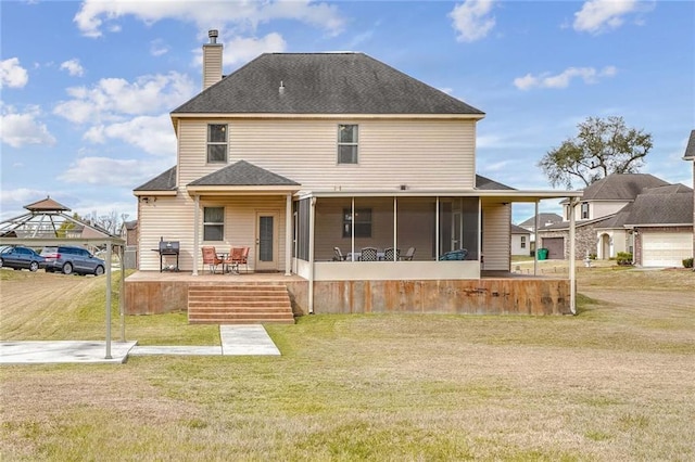 rear view of house featuring a patio area, a sunroom, and a lawn