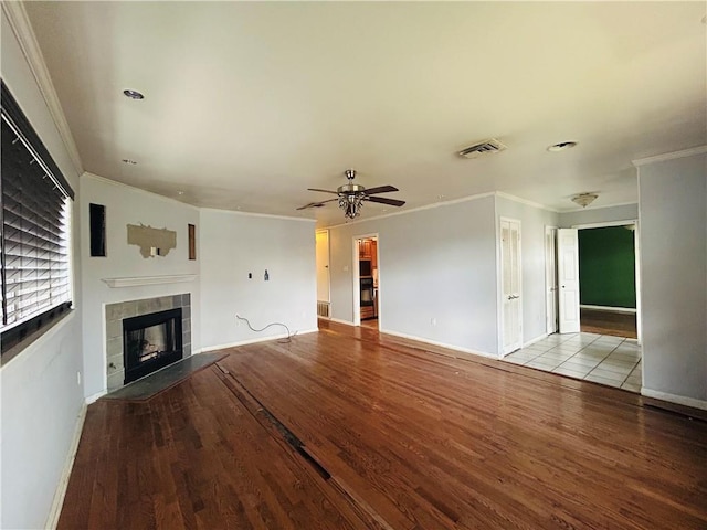 unfurnished living room featuring ceiling fan, ornamental molding, a fireplace, and light hardwood / wood-style floors