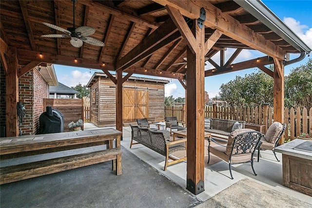 view of patio featuring a gazebo, an outdoor hangout area, ceiling fan, and a shed