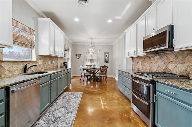 kitchen with white cabinetry, appliances with stainless steel finishes, sink, and pendant lighting