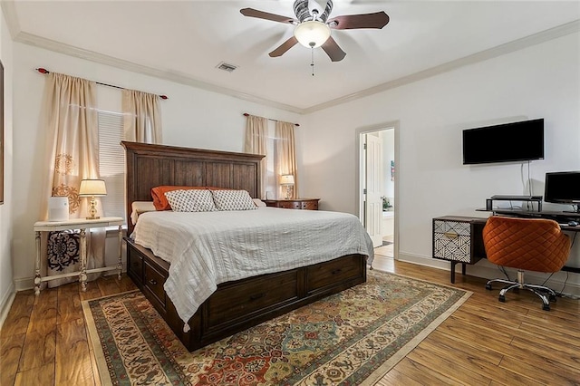 bedroom with ceiling fan, wood-type flooring, ensuite bath, and ornamental molding