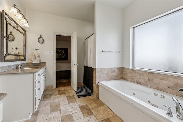 bathroom featuring a healthy amount of sunlight, vanity, and a tub