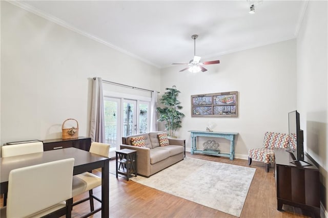 living room with ornamental molding, light hardwood / wood-style floors, and ceiling fan