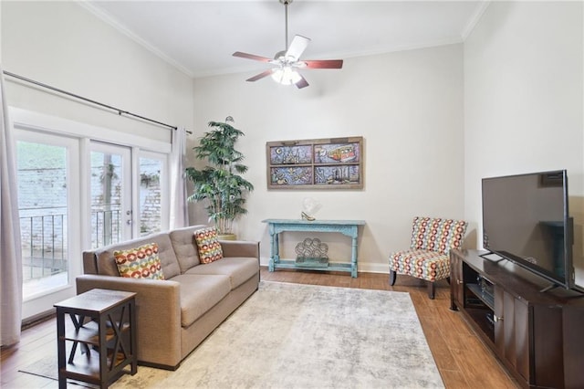 living room with crown molding, plenty of natural light, ceiling fan, and light hardwood / wood-style flooring