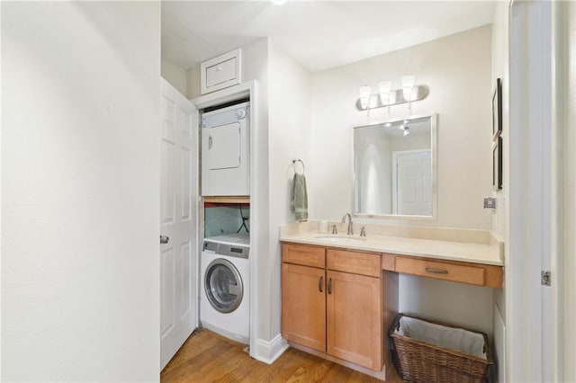 bathroom featuring stacked washer and dryer, wood-type flooring, and vanity