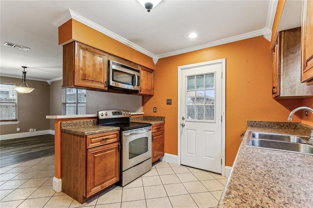 kitchen featuring appliances with stainless steel finishes, sink, hanging light fixtures, ornamental molding, and light tile patterned floors