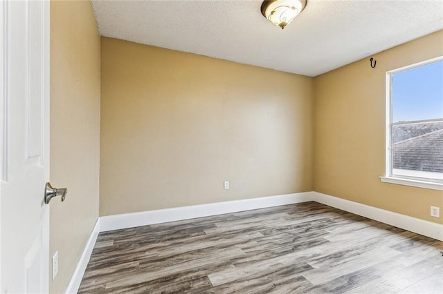 unfurnished room featuring a textured ceiling and light wood-type flooring