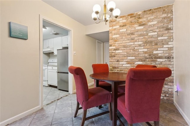 dining room with brick wall, a chandelier, and light tile patterned floors