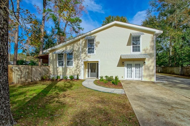 rear view of property featuring a yard and french doors