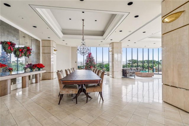 dining room featuring a raised ceiling, light tile patterned floors, a notable chandelier, and a wall of windows