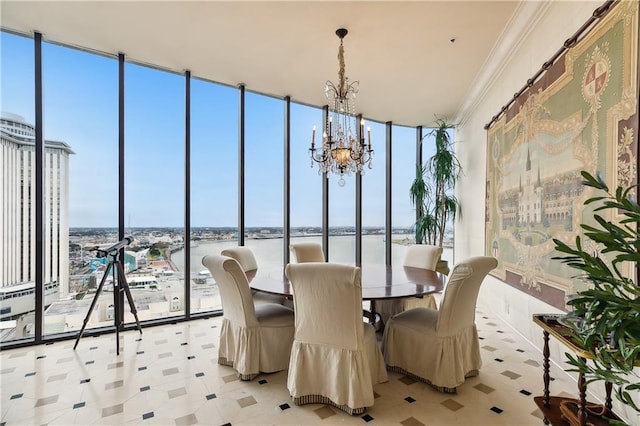 sunroom / solarium featuring a notable chandelier, a wealth of natural light, and a water view