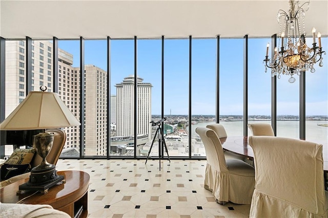 interior space featuring a water view, a chandelier, and a wall of windows