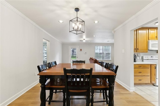 dining area with crown molding, light hardwood / wood-style floors, and a chandelier